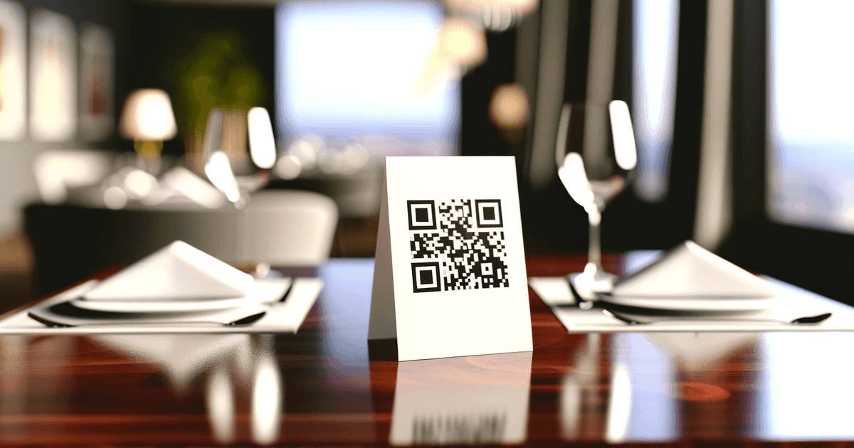 A well-designed QR code on a white table tent card in an upscale restaurant, demonstrating proper sizing and quiet zone best practices.